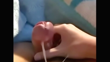 A boy squeezes his penis and ejaculates in the hole