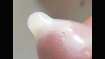 在公共厕所射精，射精射在避孕套里，精液纹理清晰可见，龟头泡精液